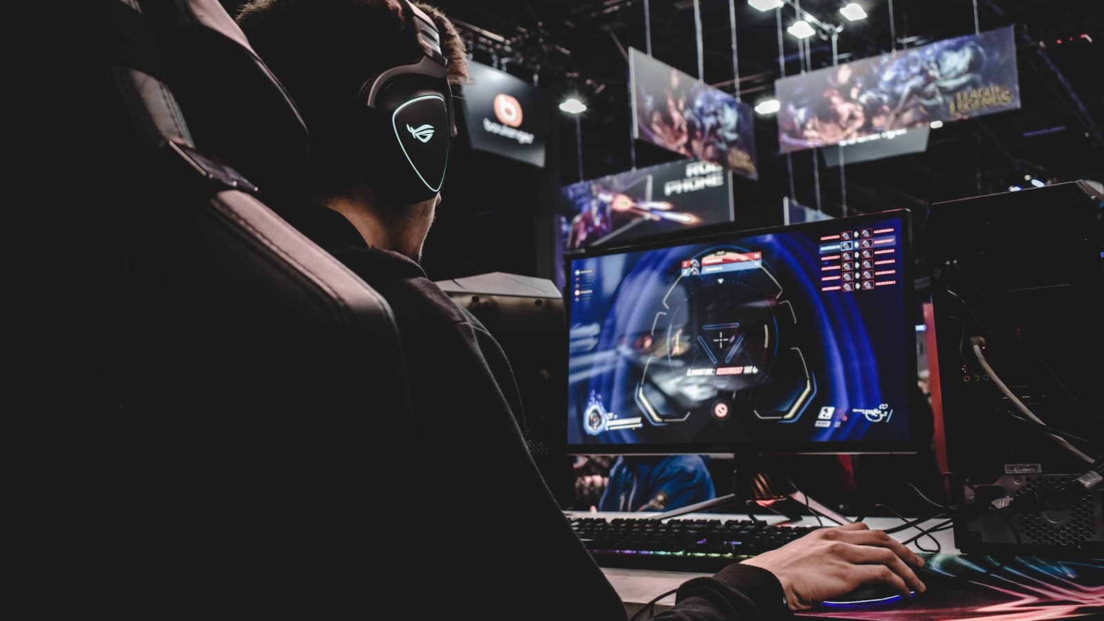 A gamer at a desktop PC with a monitor and headset