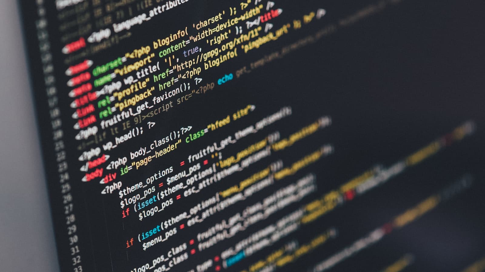 A monitor showing code in a dark editor